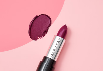 Rtěnka Mary Kay v odstínu berry vyfotografovaná se sundaným víčkem na pozadí ve dvou odstínech růžové vedle ukázky produktu.